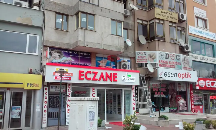 Güvenç Kartal Eczanesi cephe kampanyası — Eczanenin üst camlarındaki kampanya görsellerinin genel görünümü.