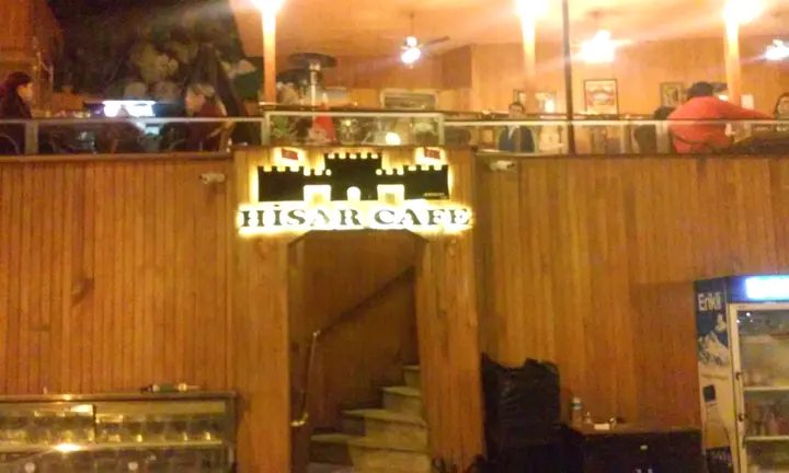 Hisar Cafe ışıklı logo — Kale figürlü tabelanın gece görünümü.