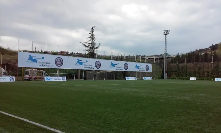 Saha çevresi reklam baskısı — Kale arkasındaki geniş sponsor baskısının görünümü.