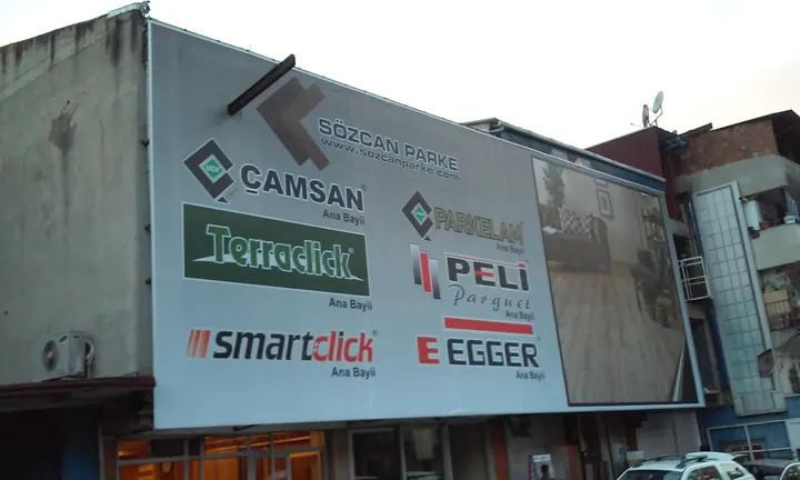 Sözcan Parke cephe baskısı — Mağaza cephesinde kullanılan geniş marka ve ürün tanıtım görseli.