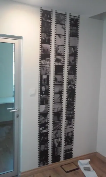 Film şeridi temalı duvar baskısı — İç mekân duvarında siyah beyaz fotoğraf şeritleri.