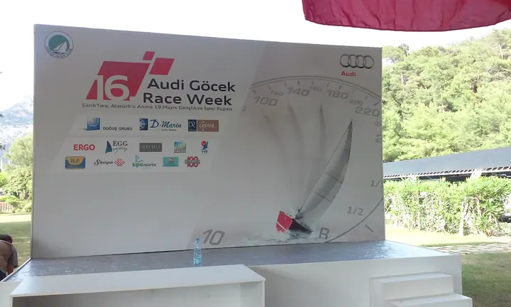Audi Göcek Race Week etkinlik fonu — Sponsor logolu açık alan etkinlik fonunun ön görünümü.